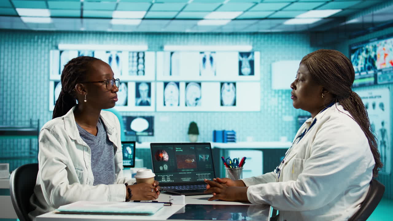Black female specialist discussing health care concerns with a young patient