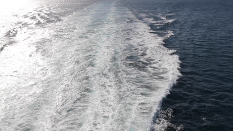 tilt wide slow-motion shot for the ocean with far mountain islands in background from cruise ship