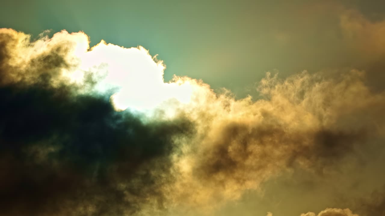 Timelapse lento di nuvole illuminate dal sole che si spostano nel cielo in modo spettacolare, rivelando un'atmosfera luminosa e una luce calda che irrompe tra le ombre in movimento