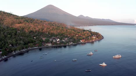 Bali-Küstenstadt-Amed-Mit-Mount-Agung-Im-Hintergrund-Mit-Sonnenaufgangslicht,-Indonesien