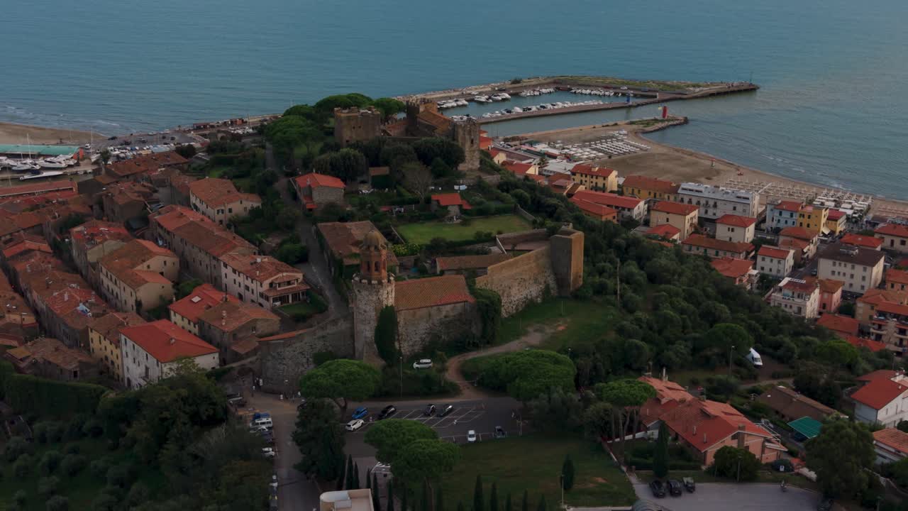 Castiglione della Pescaia castle structures, rooftops of the historic fishing town and afternoon light