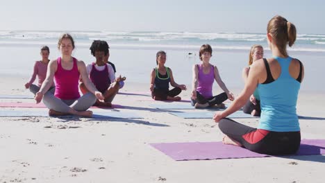 Multiethnische-Gruppe-Von-Frauen,-Die-Yoga-Position-Am-Strand-Und-Im-Hintergrund-Des-Blauen-Himmels-Machen