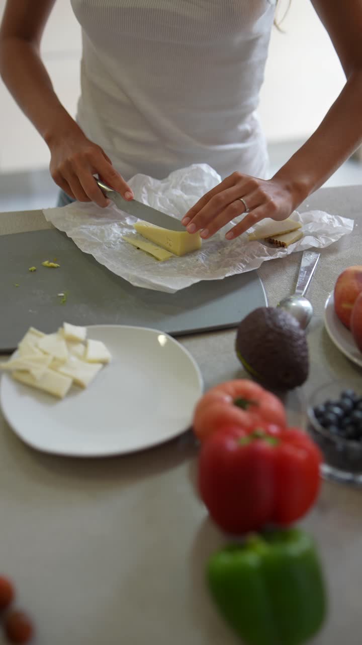 mujer preparando un desayuno o almuerzo saludable con queso y fruta