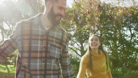 video de una feliz pareja caucásica vestida cálidamente en el jardín