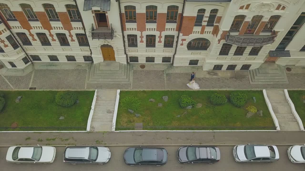 el novio y la novia caminan por la calle en el día de otoño vista superior