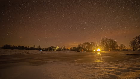 Lapso-De-Tiempo-De-La-Vista-De-La-Noche-Estrellada-Desde-El-Paisaje-Congelado-Con-Luces-De-Edificio-En-Segundo-Plano