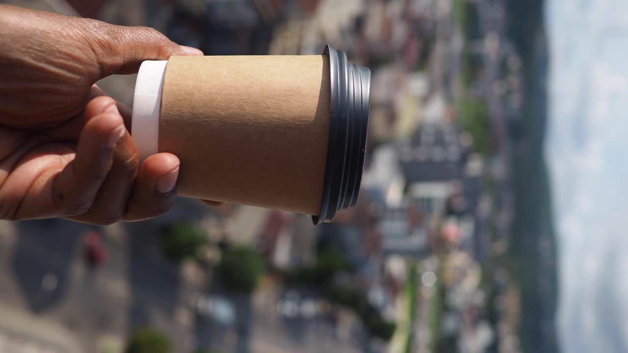 Takeaway coffee with cityscape view