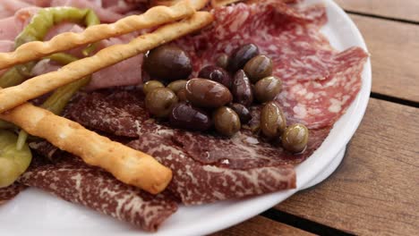 un plato de antipasto con carnes y aceitunas