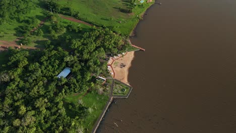 Aerial-drone-view-capturing-a-leisure-spot-along-the-Paraná-River,-revealing-a-picturesque-riverside-destination-with-recreational-facilities