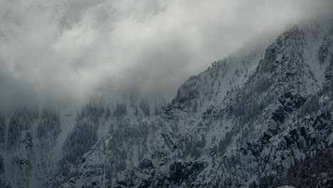 timelapse, dark clouds above snow capped hills in a cold white winter landscape