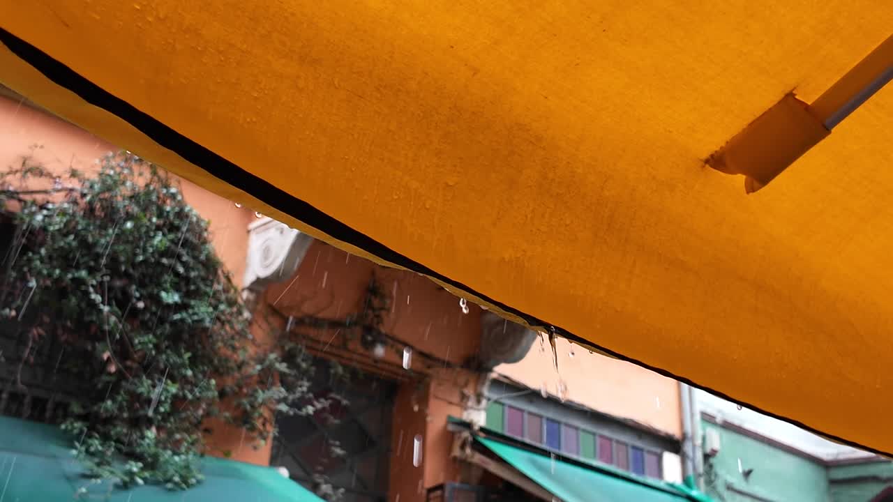 Rainy Day at a Street Cafe Under a Yellow Umbrella