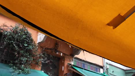 rainy day at a street cafe under a yellow umbrella