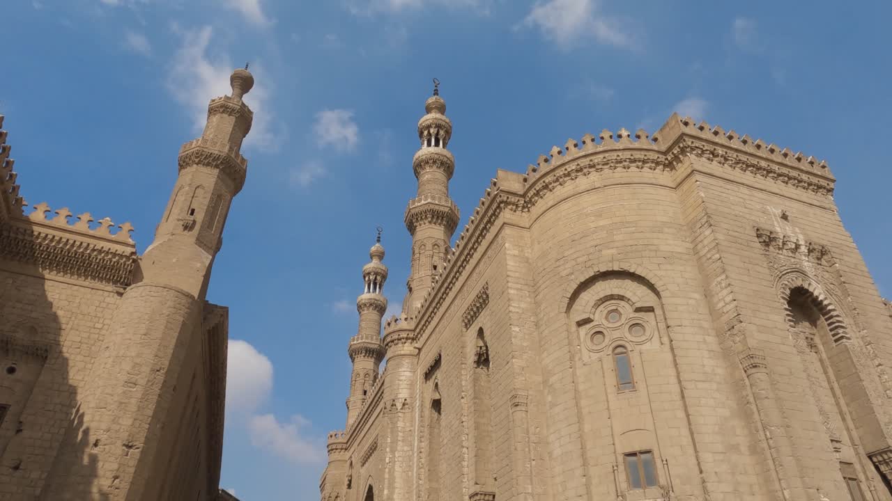 mezquita madrasa del sultán hassan y sus torres altísimas. el cairo, egipto. ángulo bajo. mantenido de la mano.