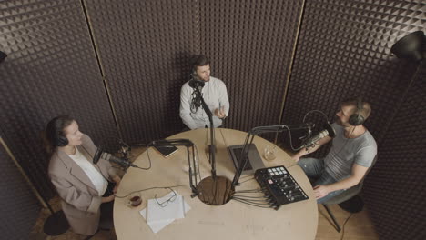 top view general shot of three people having a conversation in a radio recording studio