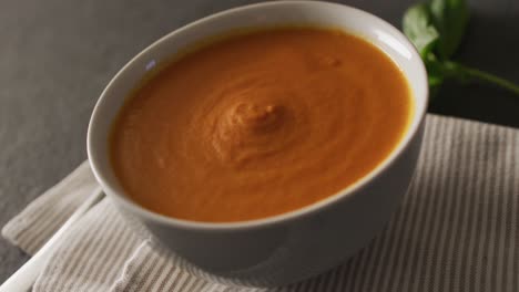 video of cream tomato soup in bowl on grey table