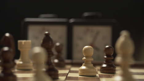 player takes turns moving chess pieces on the board and presses the clock button to stop the time