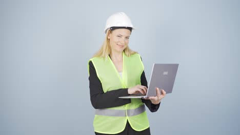 engineer holding laptop laughing at camera.