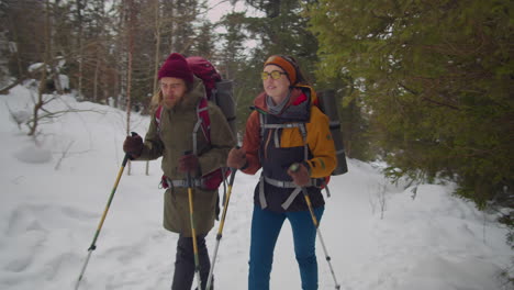 couple hiking in mountain forest on winter day