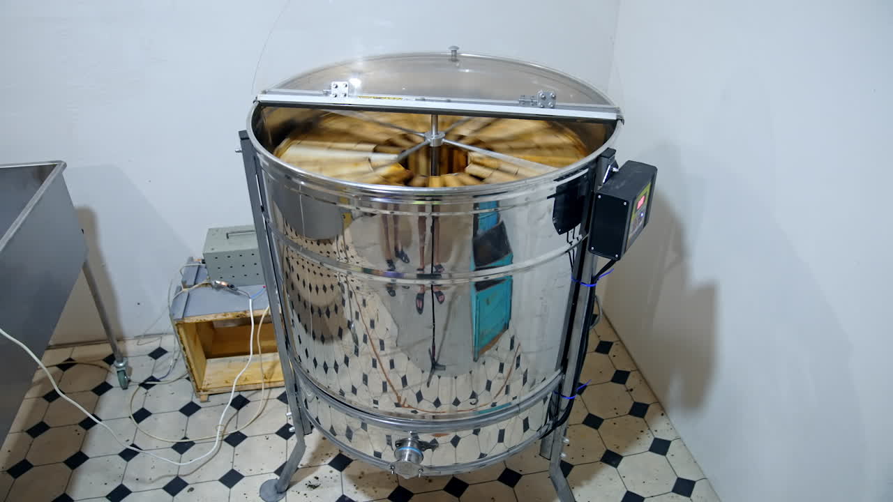 Honey extractor at beefarm. Honey extractor spinning with frames with honeycombs