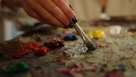 woman taking paints on palette