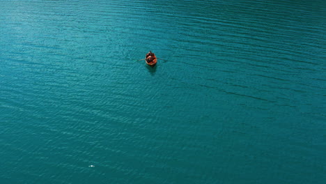 Couple-In-A-Rowboat-Paddling-On-Turquoise-Water-Surface-Of-Lake-Bled-In-Slovenia