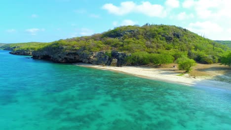 Retroceso-De-Drones-Sobre-El-Claro-Arrecife-Oceánico-De-La-Playa-De-San-Juan,-Curazao-En-Un-Día-Soleado