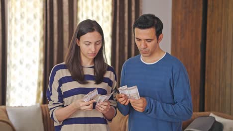 Indian-couple-counting-money-and-discussing