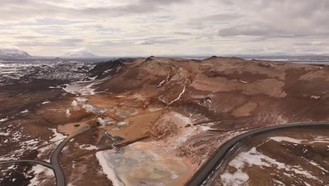 aerial view of steaming geothermal terrain and winding roads in hverarönd at námafjall. iceland
