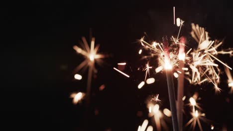 Video-of-close-up-of-sparklers-and-copy-space-on-black-background