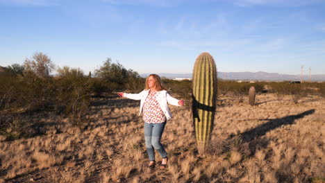 woman circling dance in cactus, still long angle shot