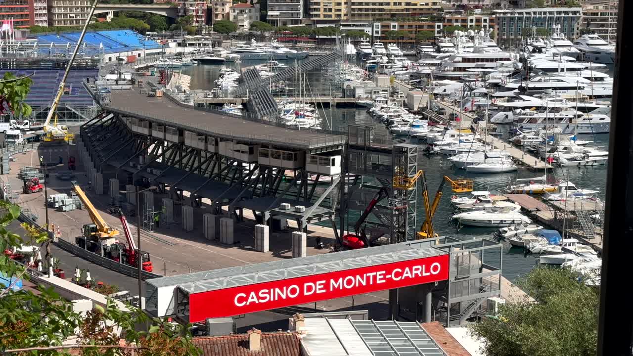 Casino de Monte Carlo Sign on race track with luxury yachts. Tilt up wide shot. Houses and homes in Background. Wide shot.