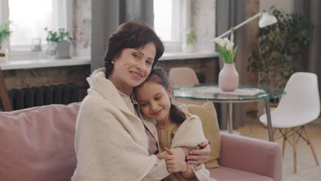 grandmother hugging her grandchild on the couch