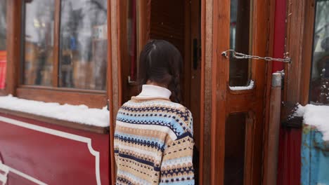 woman walking into a winter cafe