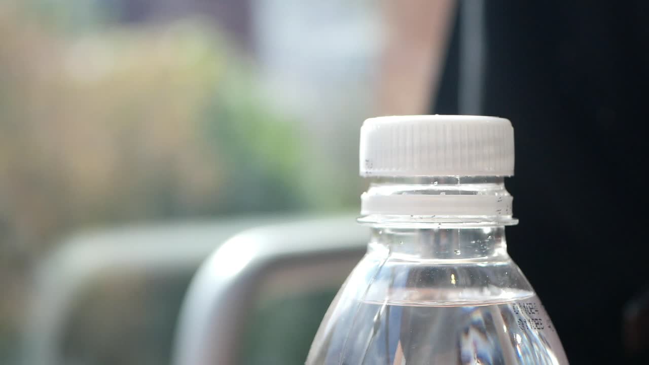 persona que sostiene una botella de agua