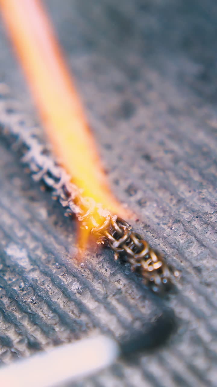 CU: applying material onto metal chain part heated with gas burner on fireproof asbestos surface extreme closeup