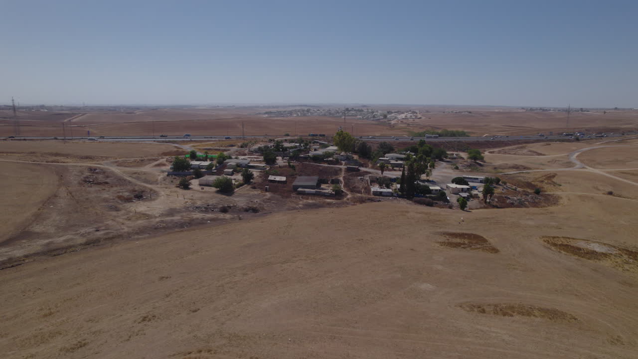 Fotografia parallasse di case senza permesso in un'area remota e desertica, vicino a un'autostrada, con terreno arido e senza colture-1