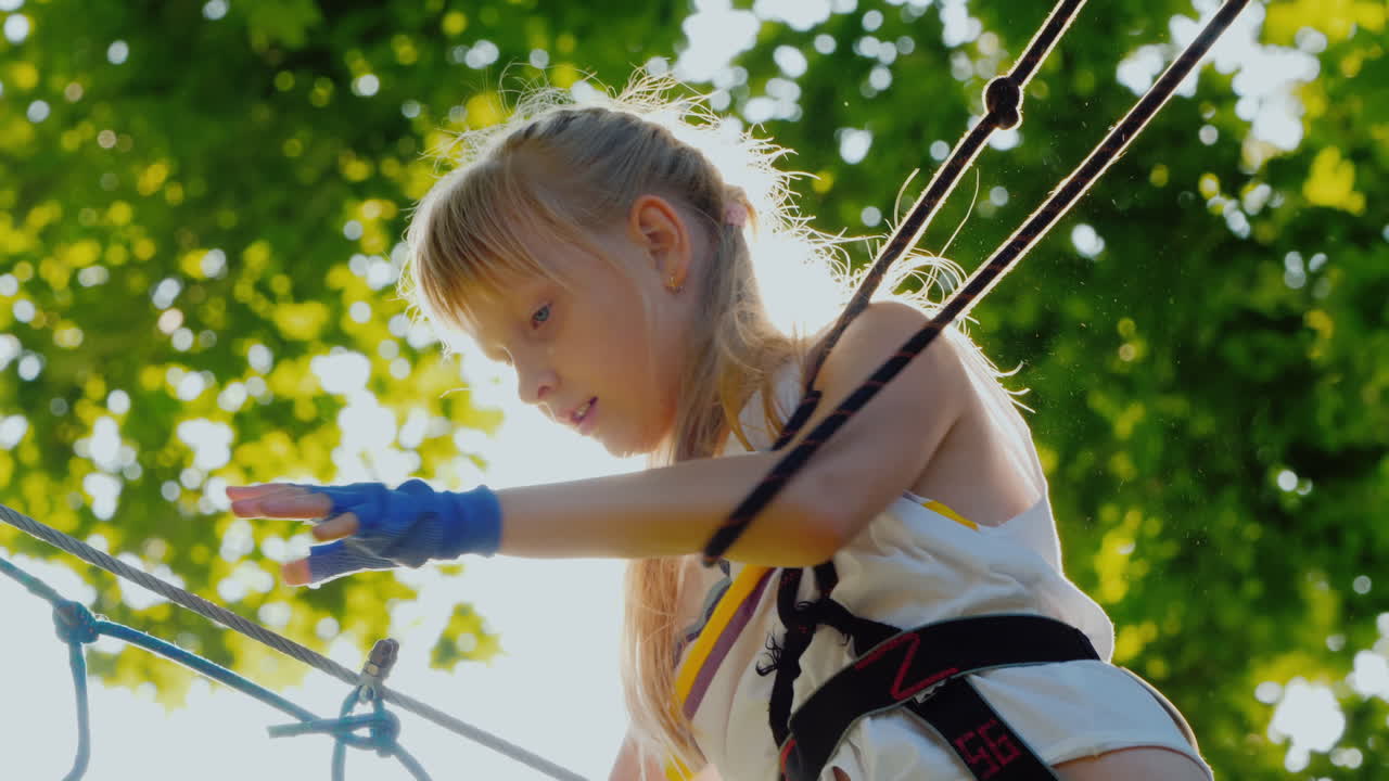 un niño valiente da pasos en un cable escalonado a una altura que supera el concepto de miedo