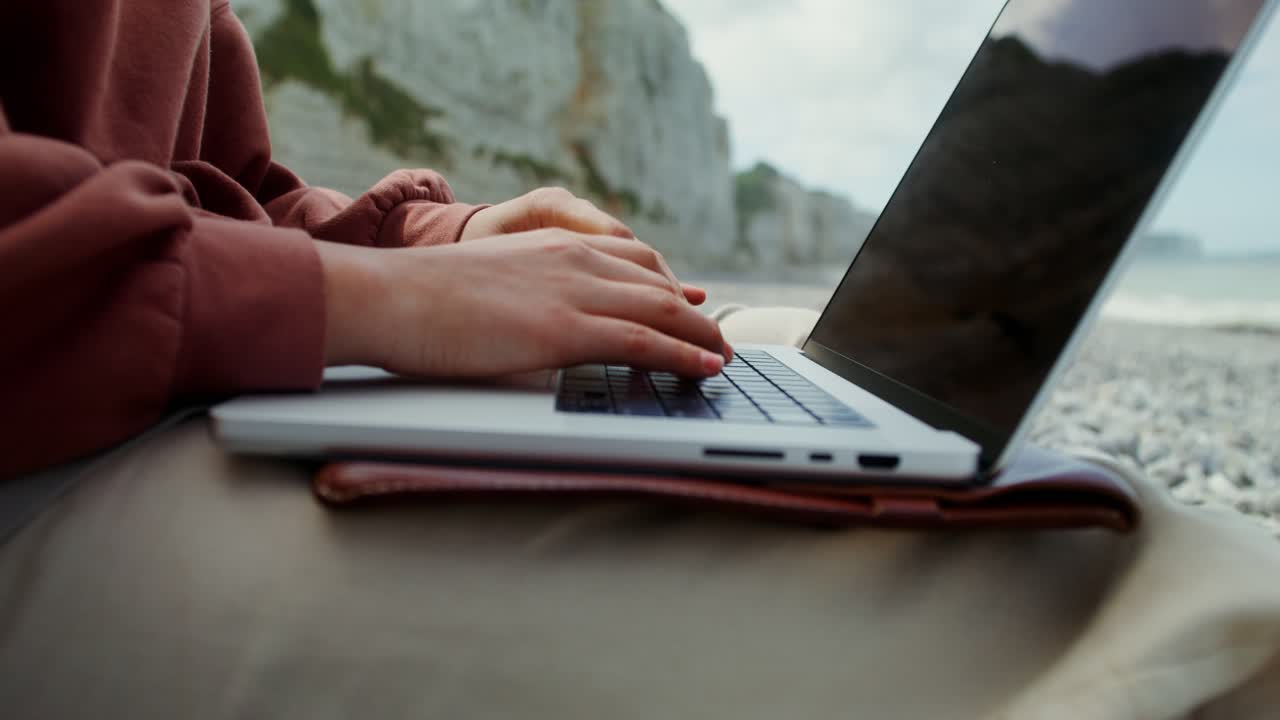 해변에서 노트북으로 일하는 여자