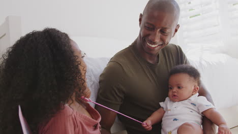 Father-And-Daughter-Dressed-As-Fairy-Sitting-In-Bedroom-Playing-With-Baby-Brother