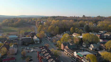 Aerial-drone-view-from-above-flying-away-from-the-sunny-suburbs-into-the-mountains-and-countryside