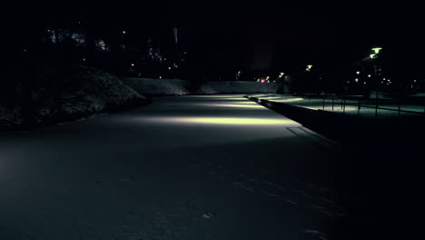 Blick-Auf-Den-Zugefrorenen-Teich,-Der-In-Einem-Stadtpark-Mit-Schnee-Bedeckt-Ist