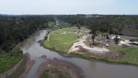 aerial view of a recreational area with a small river near by with a bridge over the river