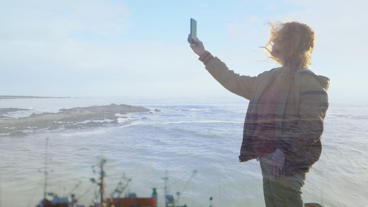 Animazione di una donna caucasica che si scatta un selfie con un paesaggio marino.