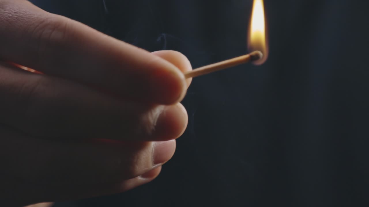 손은 스파크가 있는 상자에서 성냥을 친다 - 클로즈업