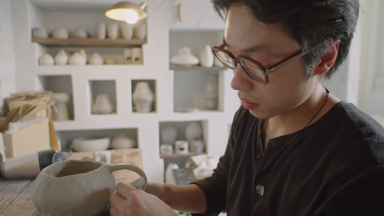 Young Asian Man Making Mug in Ceramics Workshop