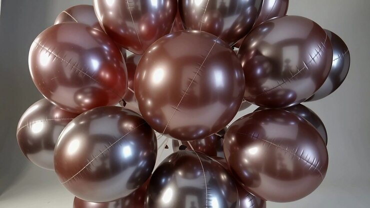La telecamera si allontana, rivelando un gruppo di palloncini metallici che ruotano nell'angolo dello studio, evidenziando le giunture