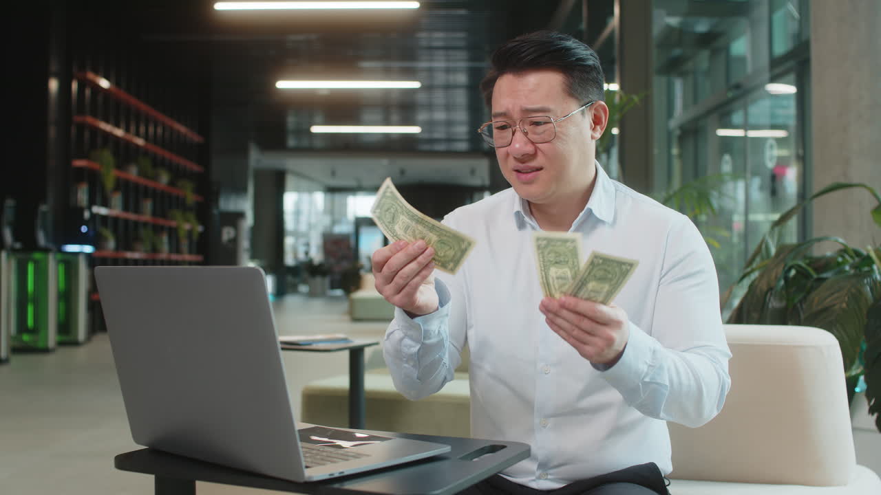 Upset businessman feeling worried about financial problems bad day sitting in modern office lobby