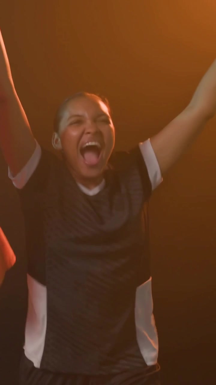 Berteriak setelah menang, pemain mengepalkan tangan, melompat, dan memeluk rekan setim di studio dengan bendera dan jersey.