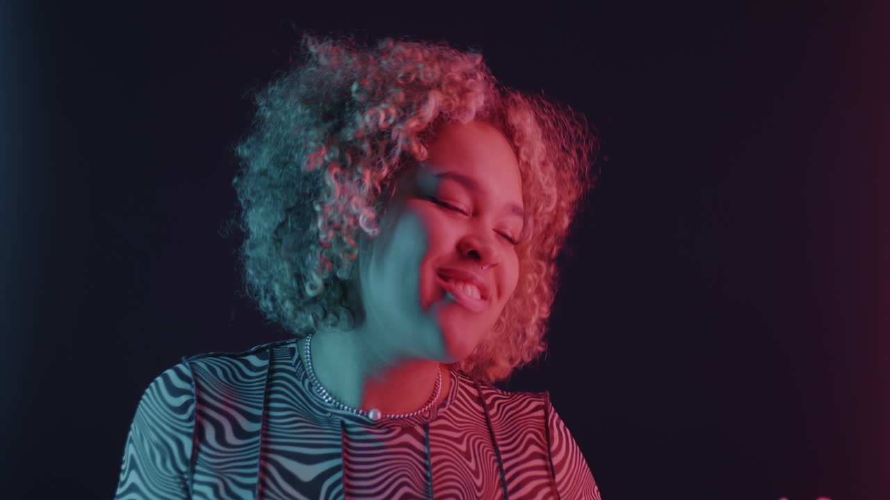 Happy Woman Dancing Under Neon Lights