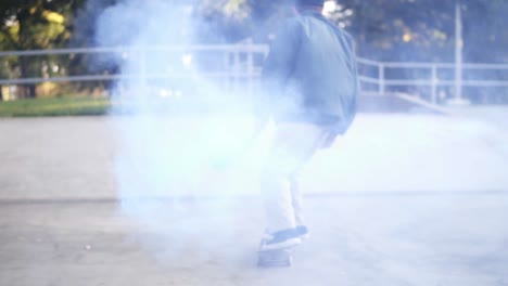 joven practicando en un día soleado de verano mientras sostiene una bomba de humo de color azul en la rampa de patinaje